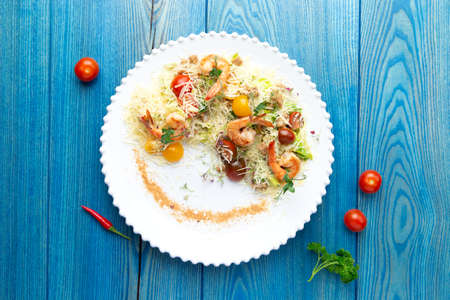 Shrimp salad in a plate. On a blue, wooden background. Selective focusの写真素材