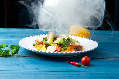 Fried perch with vegetables in a plate. On a blue, wooden background. Selective focusの写真素材