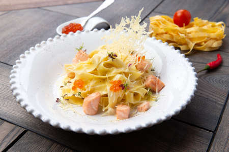 Salmon pasta in a plate. On a wooden background. Selective focusの写真素材