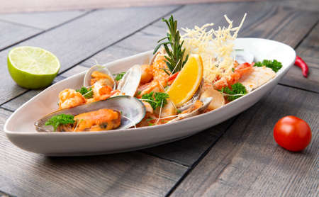 Assorted seafood in a plate. On a wooden background. Selective focusの写真素材