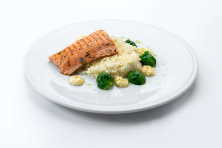 Salmon steak with rice and cauliflower in a plate. Isolated on white background.の写真素材