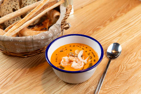 Tom yam soup and bread basket on a wooden table. Selective focus.の写真素材