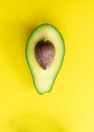 Cut avocado on a yellow background. Selective focus.の写真素材