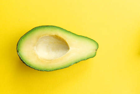 Cut avocado on a yellow background. Selective focus.の写真素材