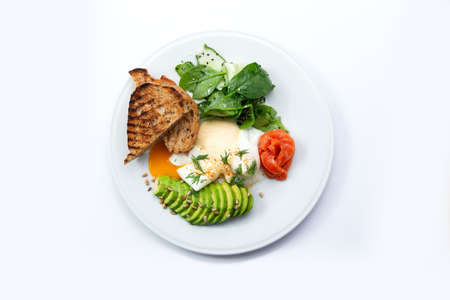 Poached egg, avocado and toast in a plate. Isolated on white. Selective focus.の写真素材