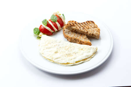 Omelet and toast on a plate. Isolated on white. Selective focus.