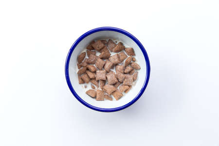 Dry breakfast pads. With milk. In a plate. Isolated on white. Selective focus.の写真素材