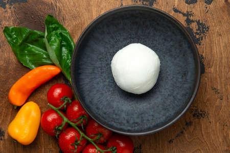 A ball of mozzarella cheese on a wooden table. Selective focus.の写真素材