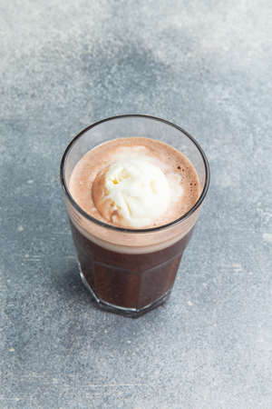 Coffee drink with ice cream in a glass. On a gray background.