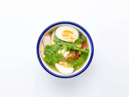Traditional chicken and egg soup. On white background. view from above.