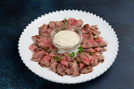 Beef slices and sauce in a plate on a dark background. selective focus.