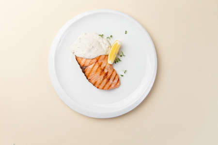 Fried salmon fillet and sauce in a plate. selective focus.の写真素材