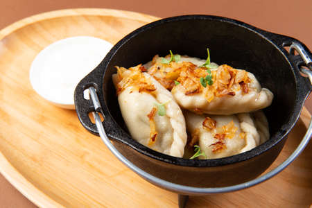 Vareniki with potatoes. Fed up with fried onions. selective focus.