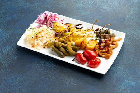 Assorted pickled vegetables in a bowl. On a gray background. selective focus.
