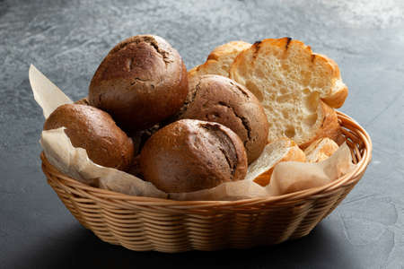 Basket with different types of bread. On a gray background. selective focus.