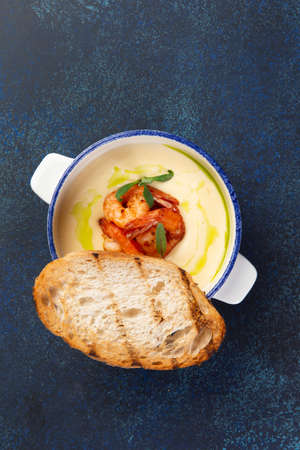 Cream soup with shrimps and a fried piece of bread. selective focus.