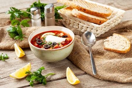 Traditional hodgepodge soup in a bowl on a wooden table. selective focus.の写真素材