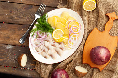 lard and new potatoes in a plate on a wooden table. selective focus.