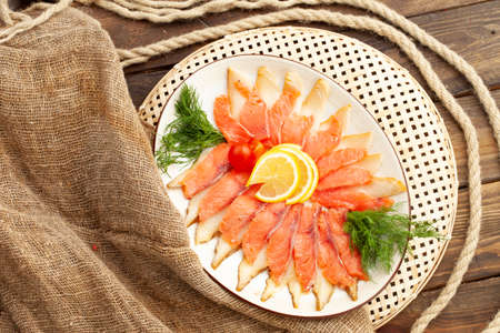 Assorted fish cut in a plate on a wooden table. selective focus.の写真素材