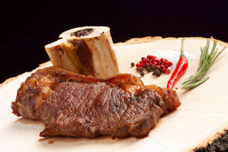 Steak on a wooden plate. On a dark background. selective focus.