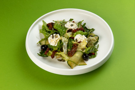 Salad with cucumbers and sun-dried tomatoes in a plate on a green background. selective focus.