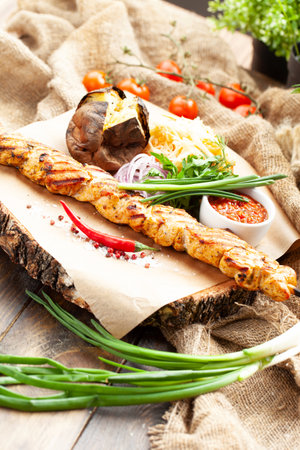 Chicken skewers on a skewer. On a wooden tray. selective focus.の写真素材