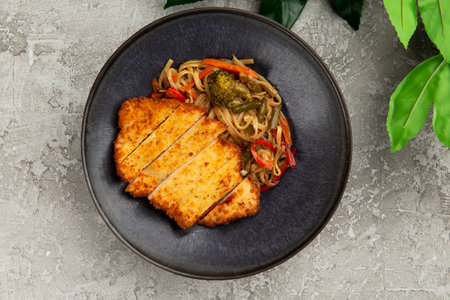 Fried chicken and wok noodles in a plate. on a gray background. selective focus.の写真素材