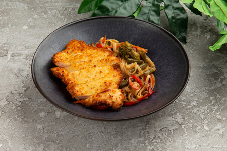 Fried chicken and wok noodles in a plate. on a gray background. selective focus.の写真素材