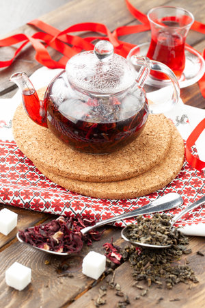 Tea with berries in a transparent teapot on a wooden table. selective focus.の写真素材