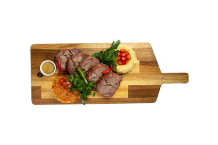 Cooked tenderloin meat and mashed potatoes on a wooden board. isolated on white.の写真素材
