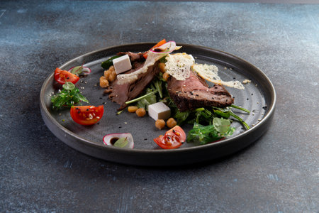 Cooked meat slices and salad in a plate. selective focus.の写真素材