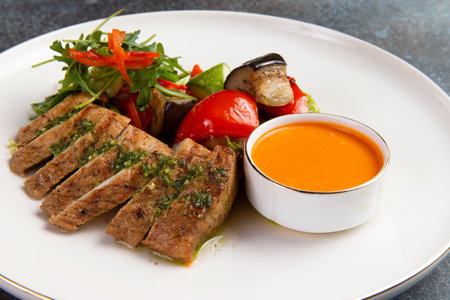 Fried turkey fillet, sauce and salad in a plate. selective focus.の写真素材