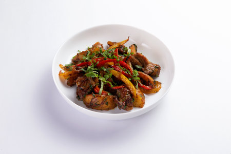 Fried meat with potatoes and vegetables in a plate. On a light background. selective focus.の写真素材
