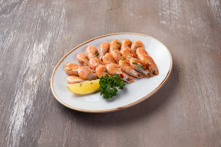 Cooked shrimp and lemon in a plate on a brown background. selective focus.の写真素材