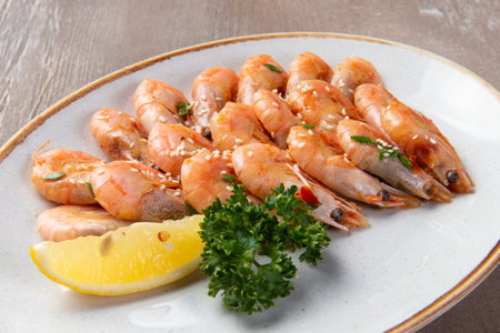 Cooked shrimp and lemon in a plate on a brown background. selective focus.の写真素材
