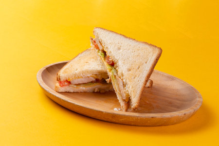 Sandwich with ham cheese and herbs on a yellow background. Selective focus.の写真素材