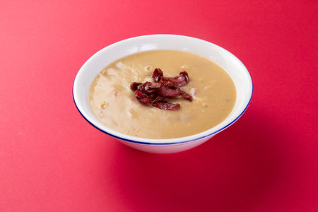 Cream soup with sausages in a plate. Selective focus.