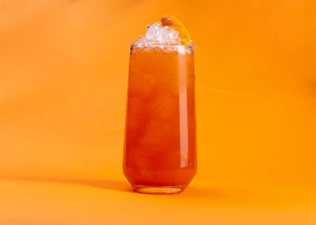 Cocktail with ice and orange on a orange background. Close-up.の写真素材