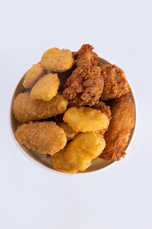 Fried chicken wings, strips and nuggets in a bucket. Isolated on white.