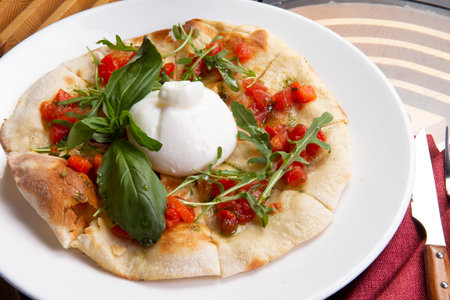 Focaccia with buratta cheese in a plate. Selective focus.