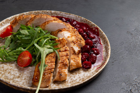 Fried chicken breast and arugula on a plate. On a dark background. Selective focus.の写真素材