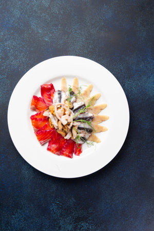 Assorted fish slices on a plate on a dark background. Selective focus.の写真素材