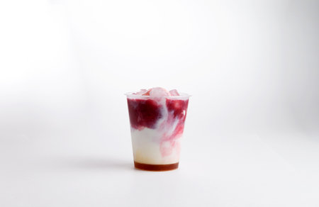 Milkshake with red syrup, in a glass. on a white background. Selective focus.の写真素材