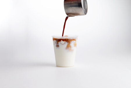 Cold coffee with milk in a plastic cup. on a white background. Selective focus.の写真素材
