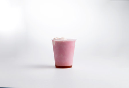 Milkshake with red syrup in a cup. on a white background. Selective focus.の写真素材