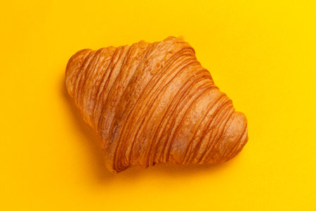 Croissant on a yellow background. Selective focus.