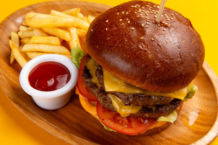 A delicious cheeseburger with fries and sauce. Selective focus.の写真素材