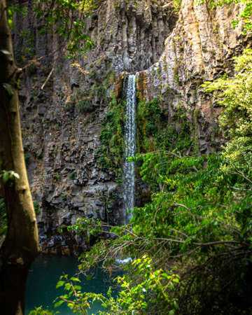 Waterfall in the middle of a rock wall and a lake Vertical photo of the waterfall in the middle of a rock wall and a lake. Leona salt in Chileの写真素材