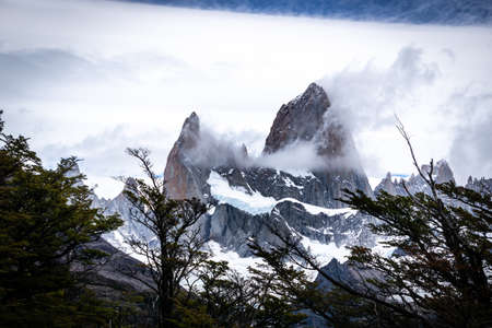Rocky snowy mountain peaks with the sun rising behind and red clouds. Fitz Roy in Argentinaの写真素材