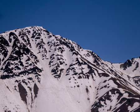 Snowy road between the mountains of Cajon del Maipo, Road to El Yeso Reservoirの写真素材